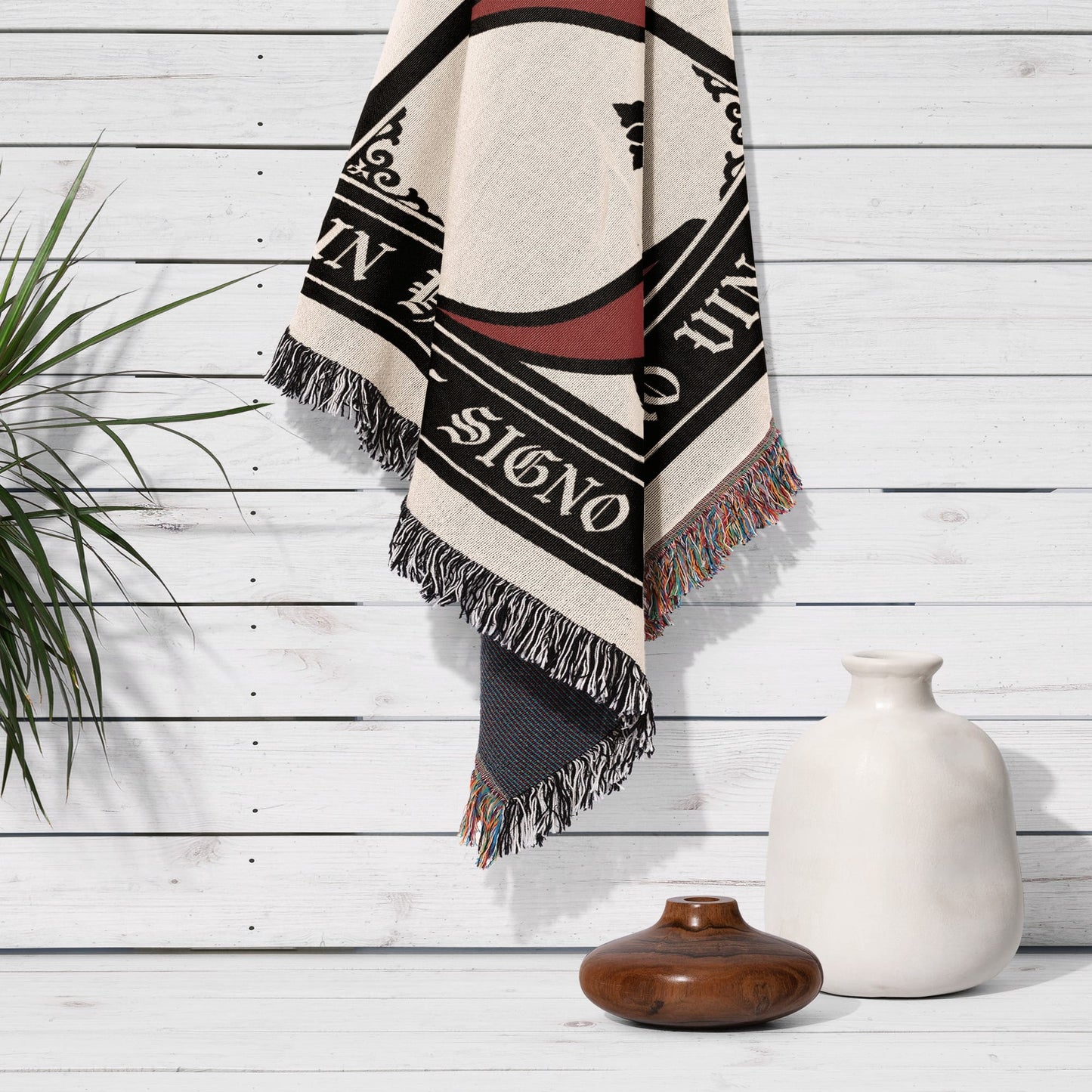 Tapestry with text "IN HOC SIGNO VINCES" hangs on a white wall.