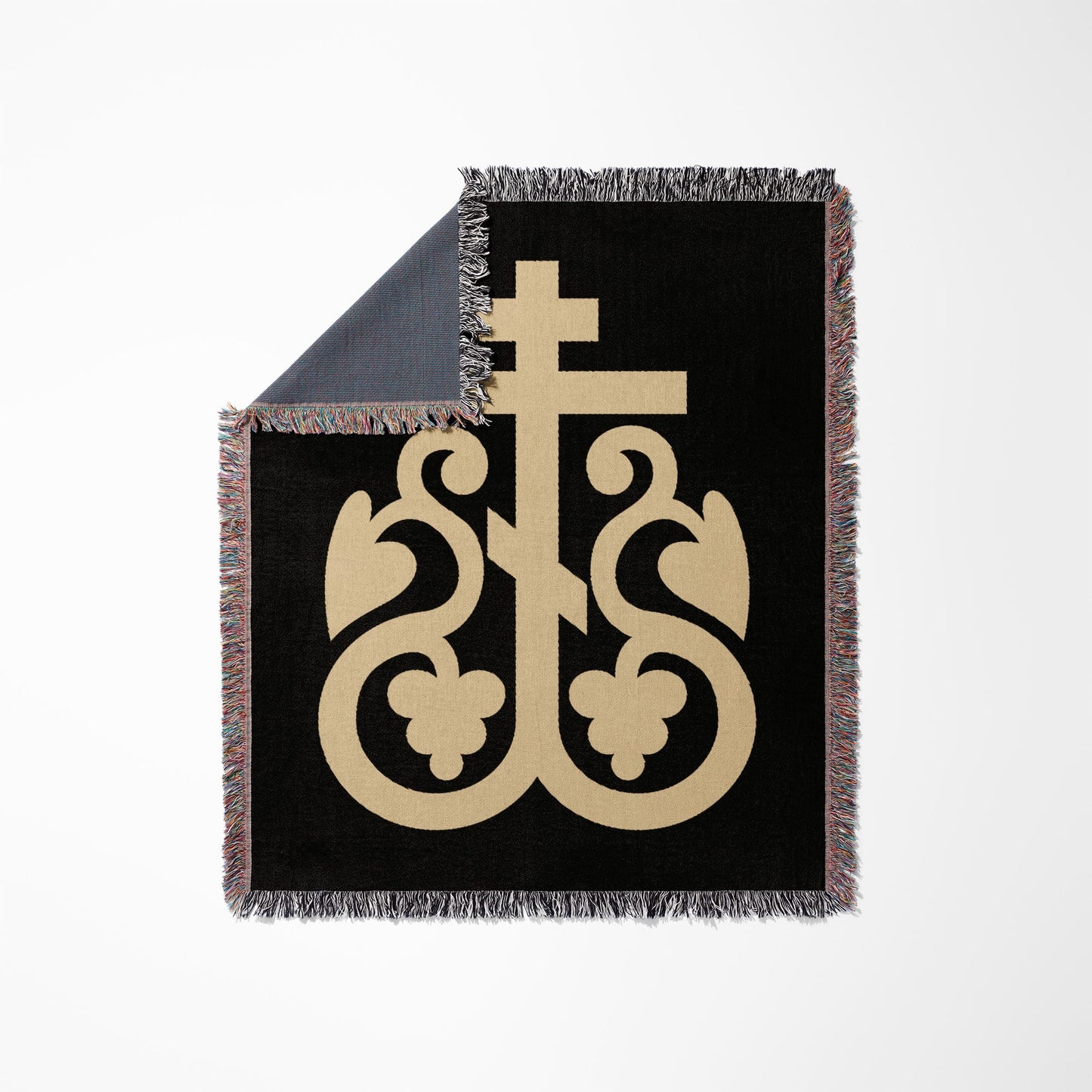 Black throw blanket with ornate beige cross design and fringed edges.