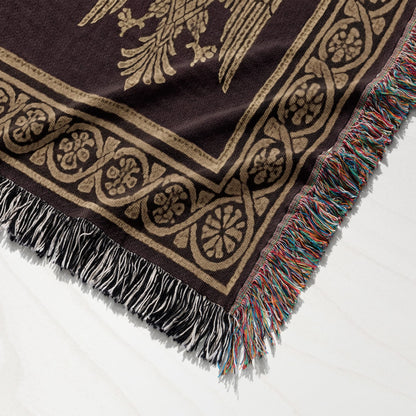 Brown tapestry blanket with gold eagle design and tasseled edge.