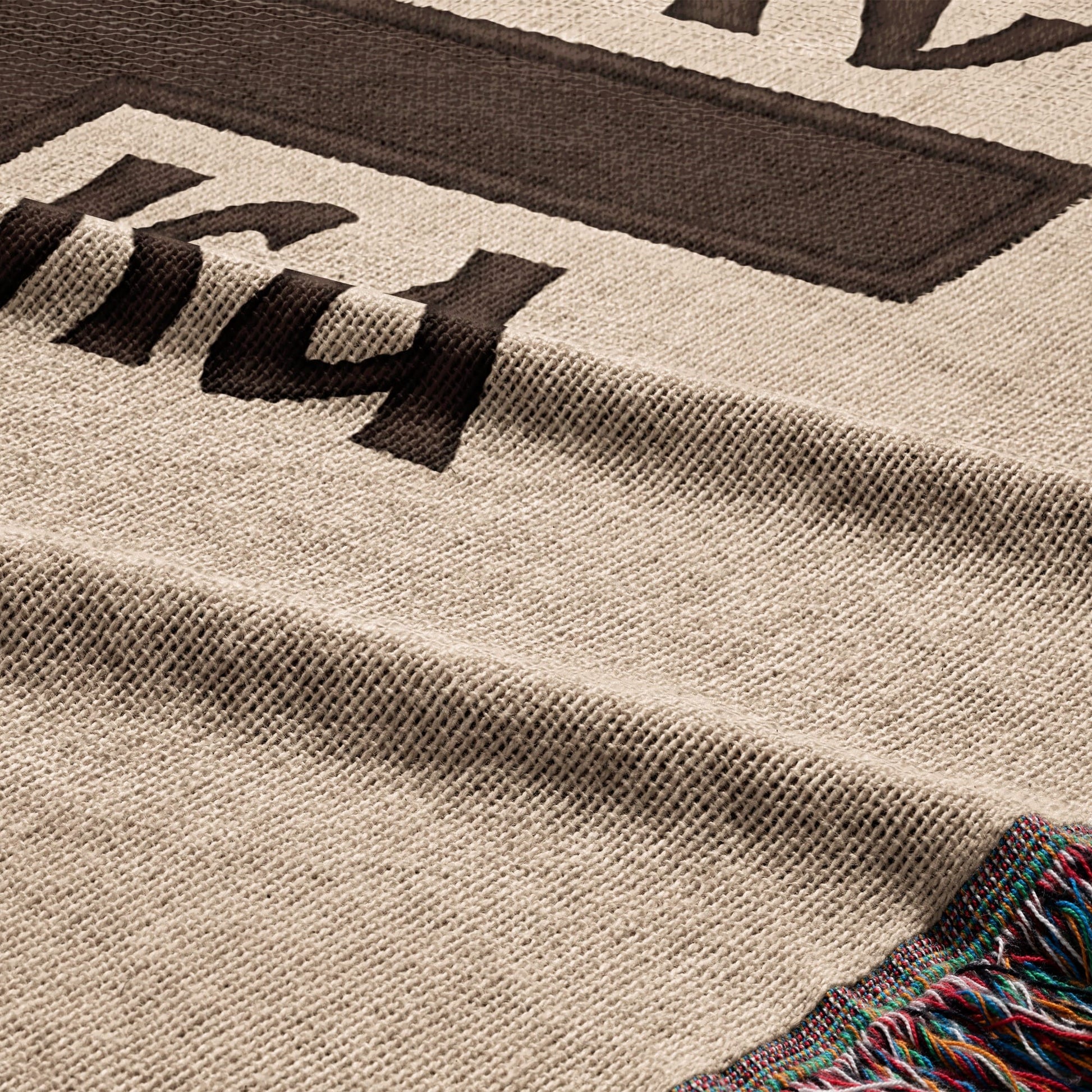 Woven throw blanket with a large dark brown "14" design and colorful fringe.