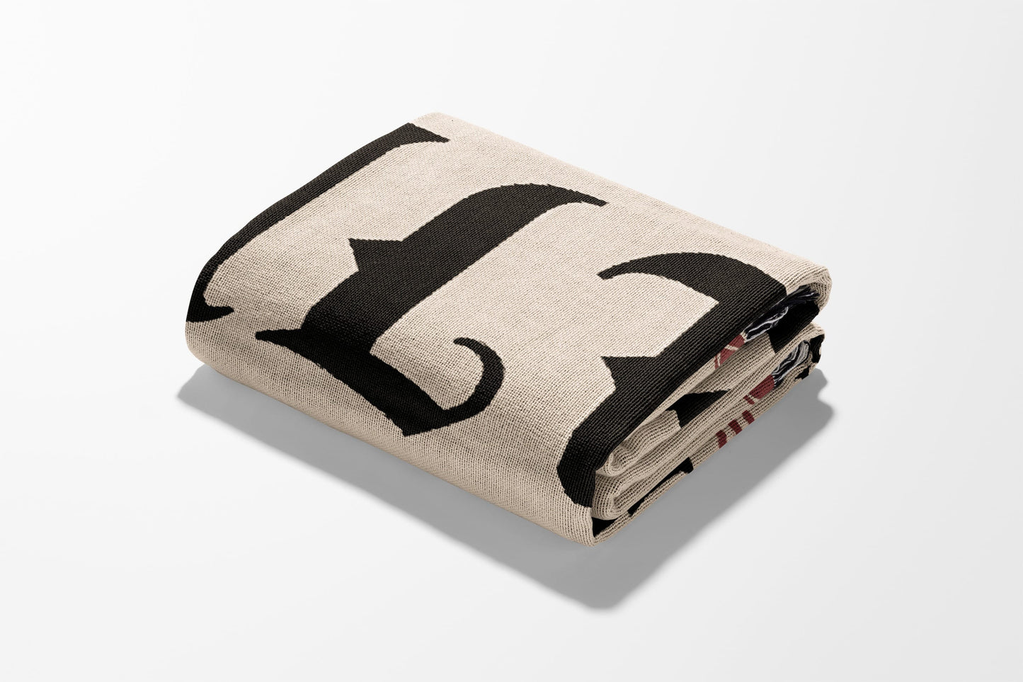 Folded tan blanket with large black letter F.
