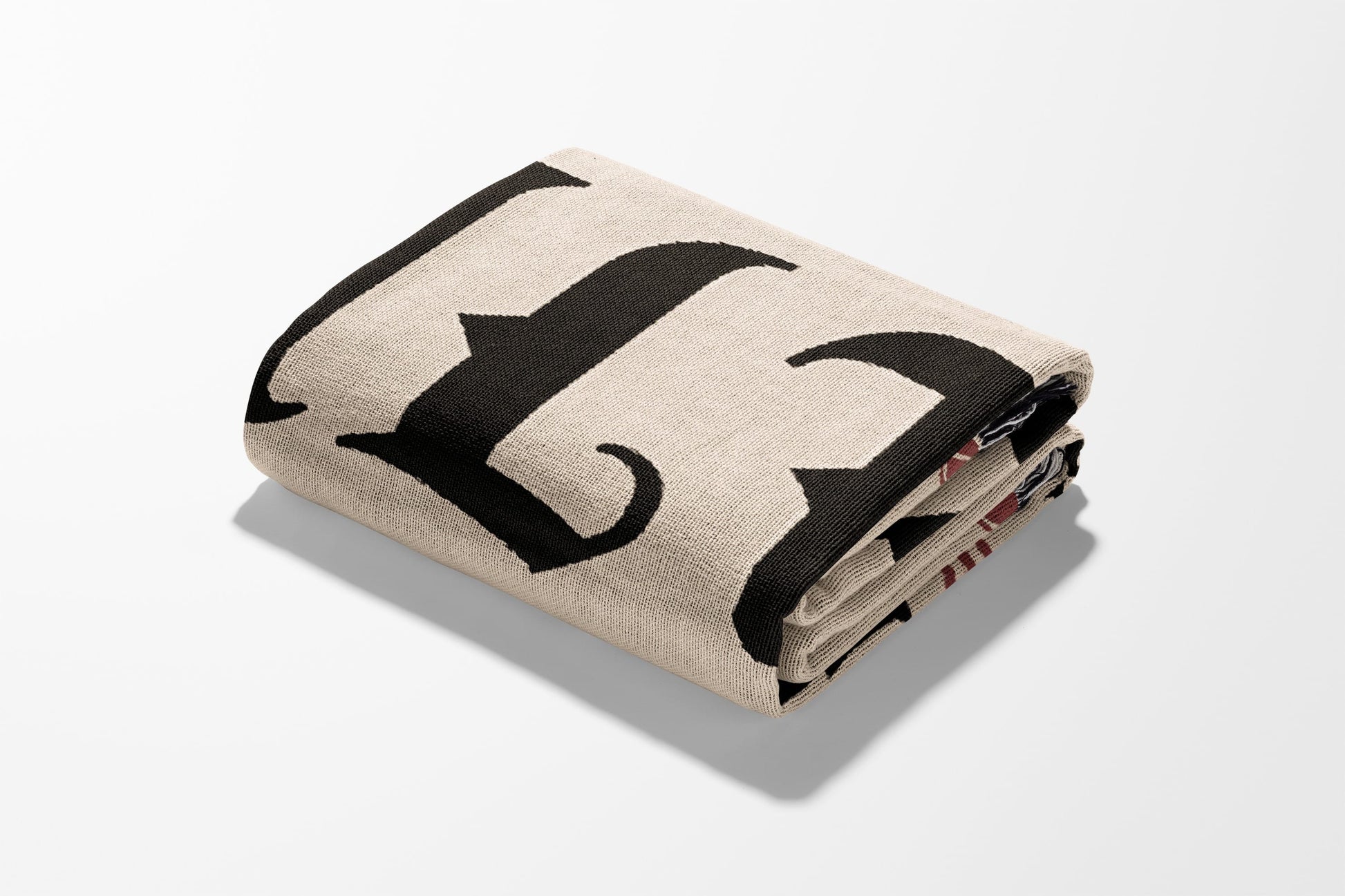 Folded tan blanket with large black letter F.