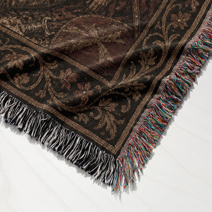Dark brown woven blanket with fringe and intricate floral pattern.