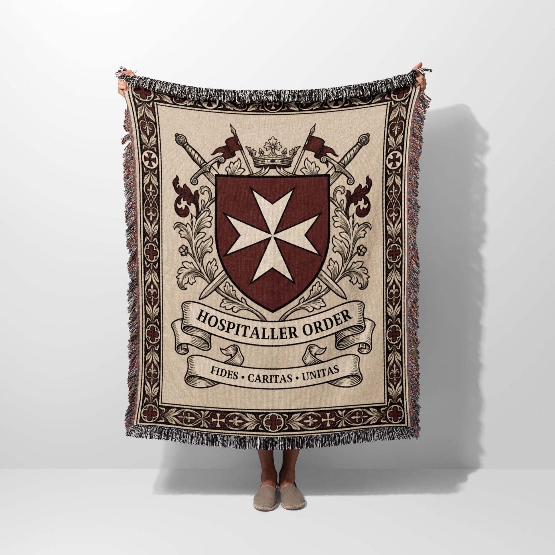 Woven blanket with Hospitaller Order crest, swords, crown, and motto.