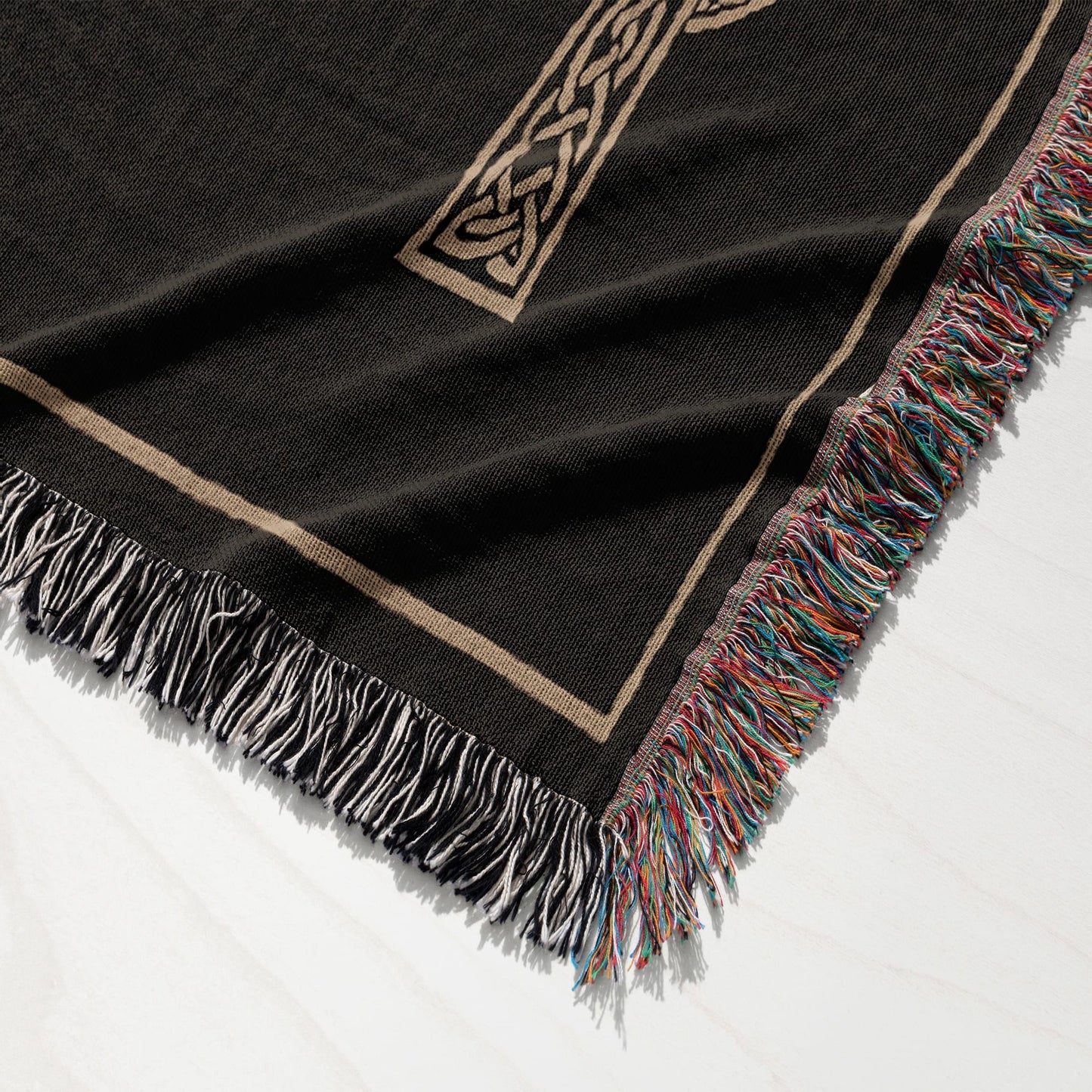 Black throw blanket with a Celtic knot design and fringed edges.