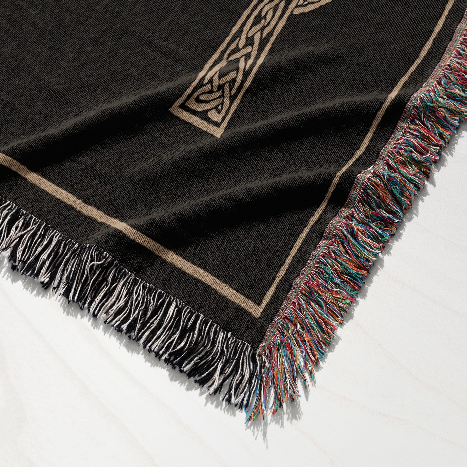 Black throw blanket with a Celtic knot design and fringed edges.