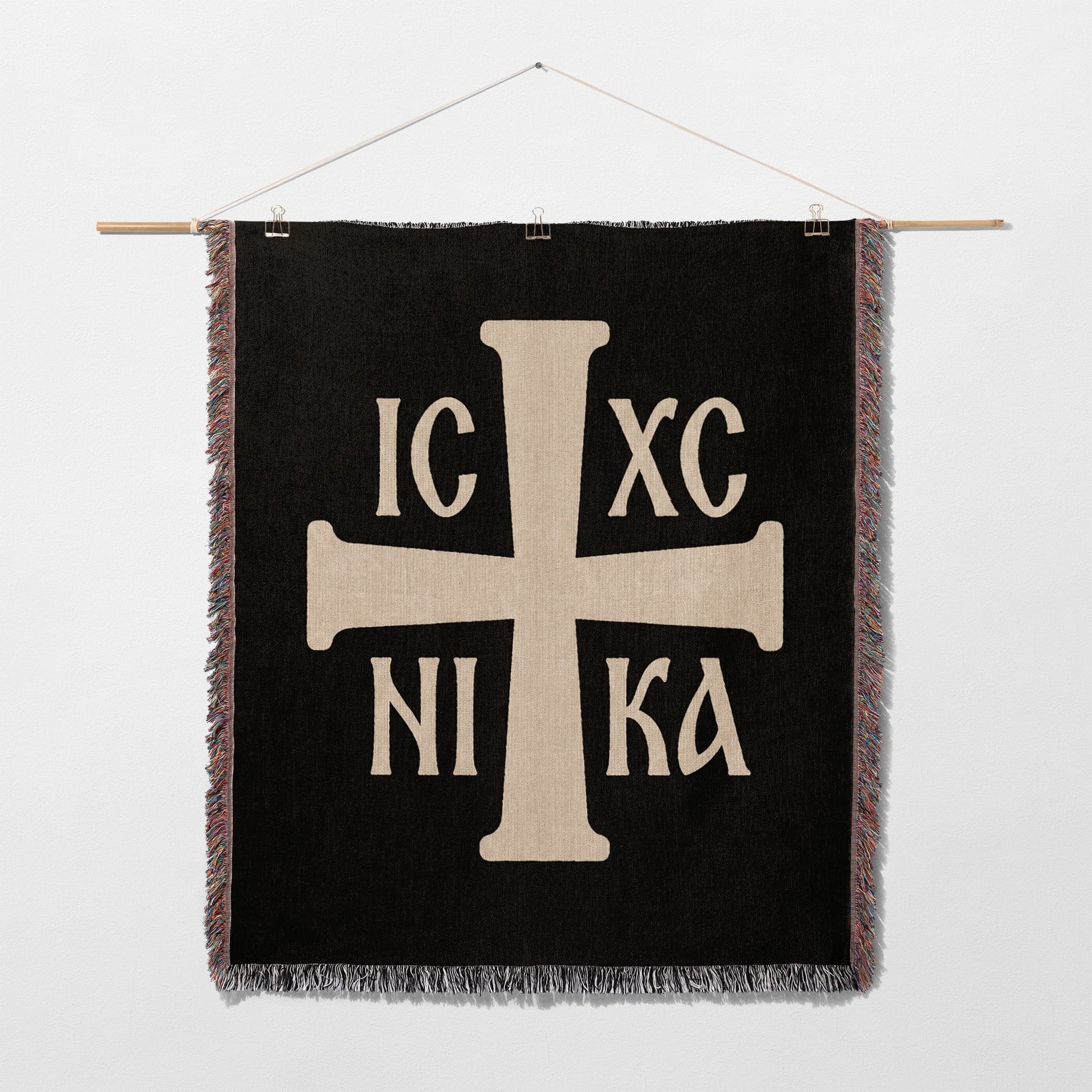 Black tapestry featuring a prominent cream-colored Orthodox Christian cross with text.