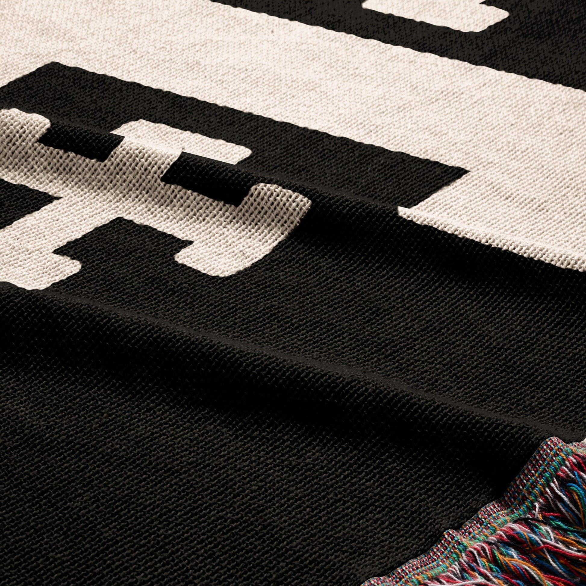 Black and white striped blanket with tasseled edge.