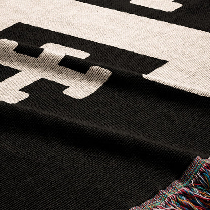 Black and white striped blanket with tasseled edge.