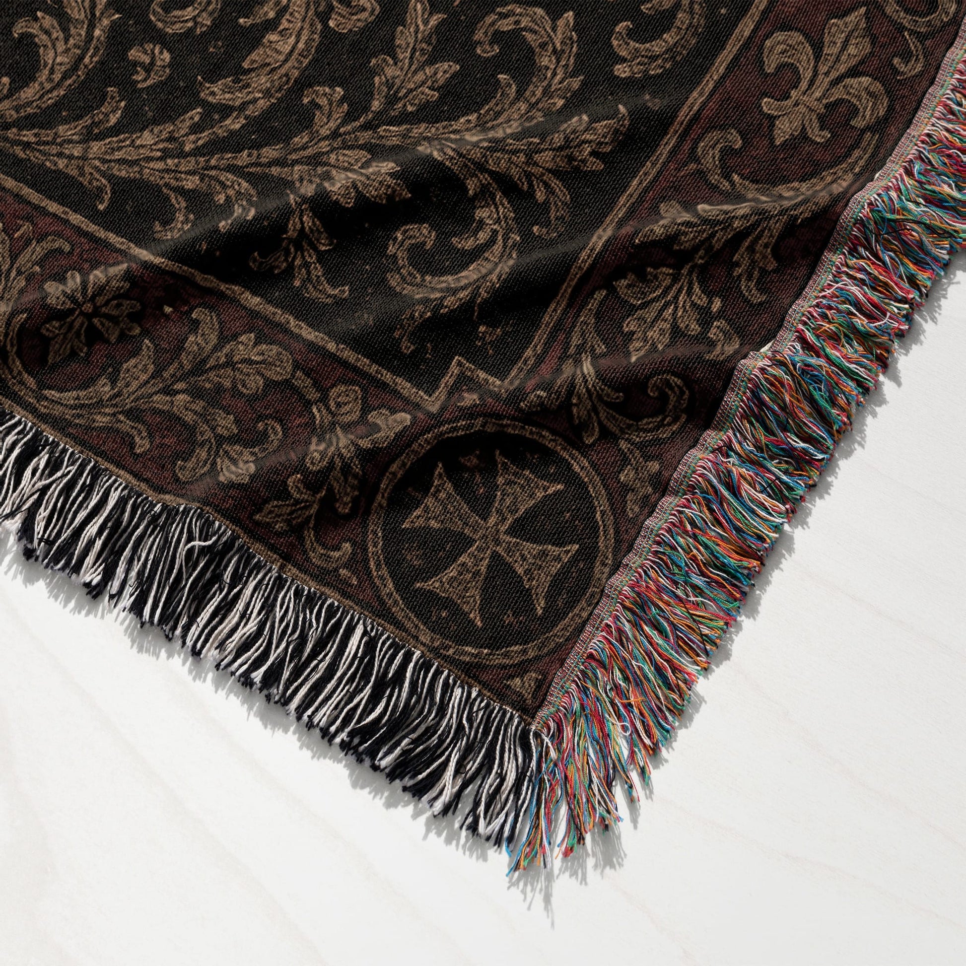 Woven blanket with ornate dark brown damask pattern and fringe.