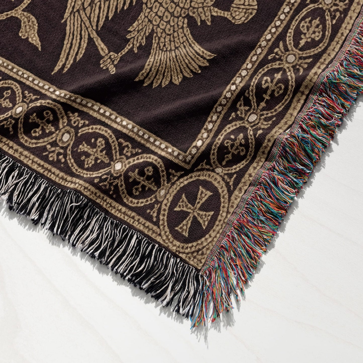 Brown throw blanket with gold Byzantine eagle pattern and fringed edges.
