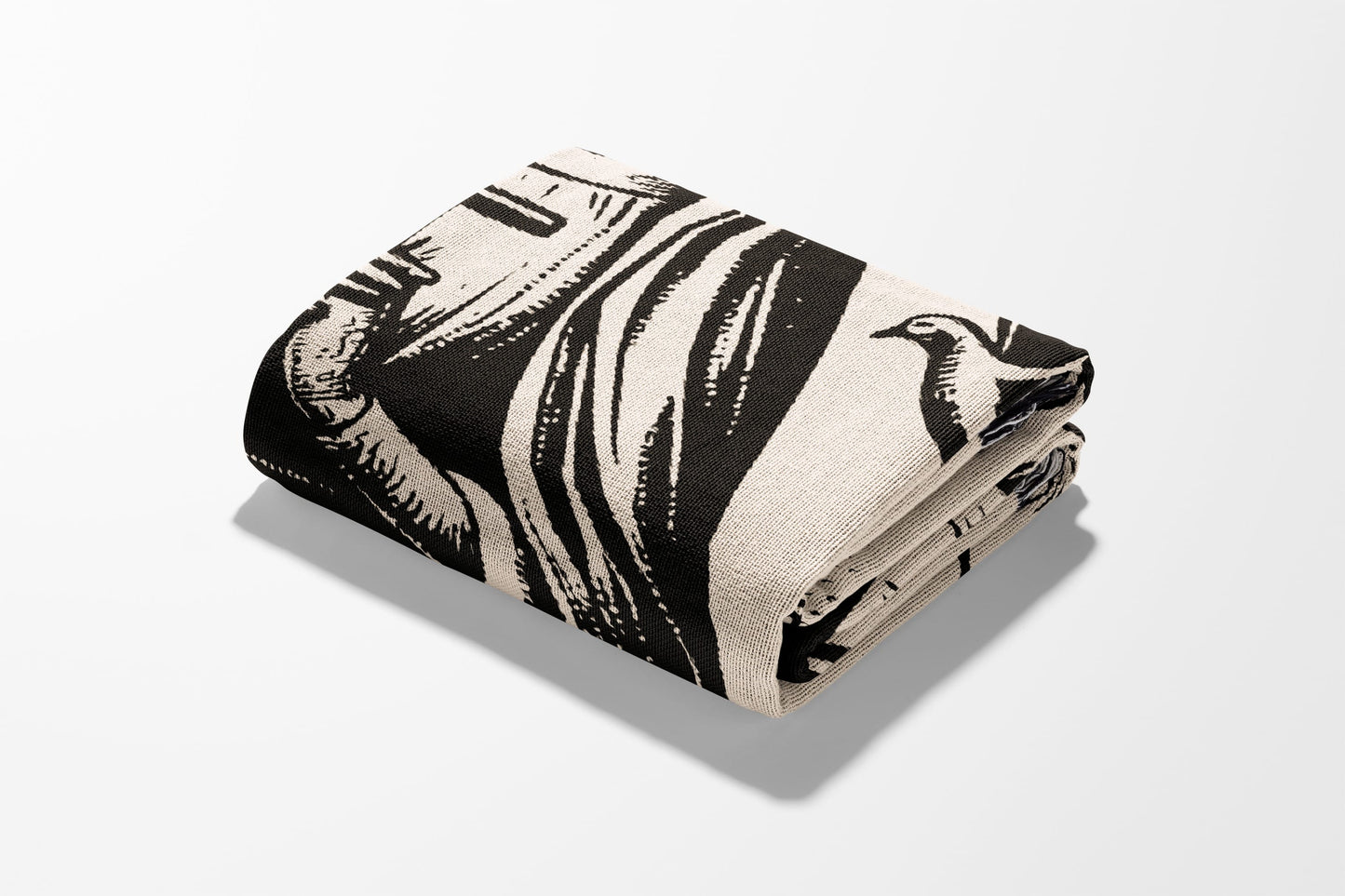 Folded blanket with black and white illustrated pattern of people and birds.