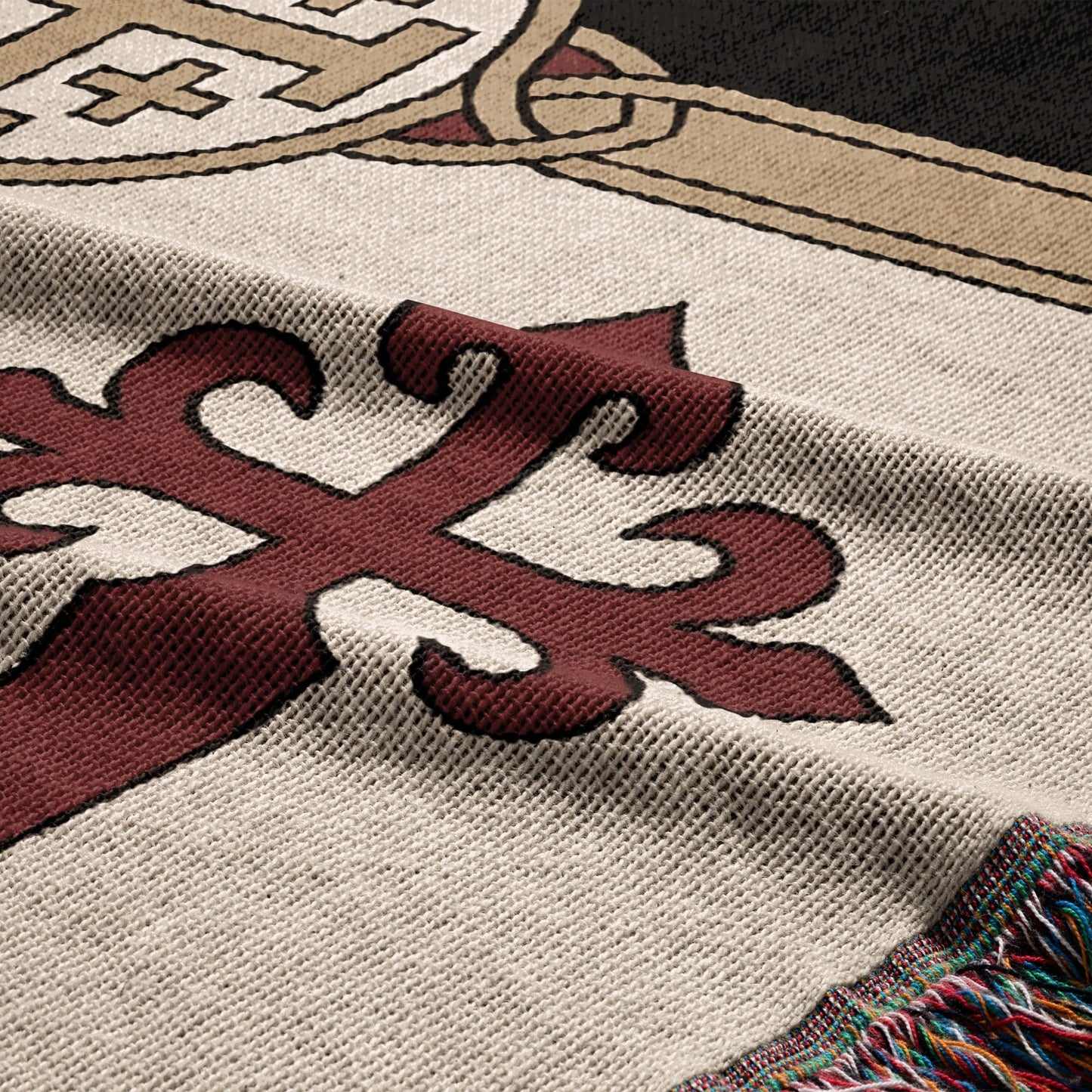 Cream woven blanket with a red stylized cross and fringed edge.