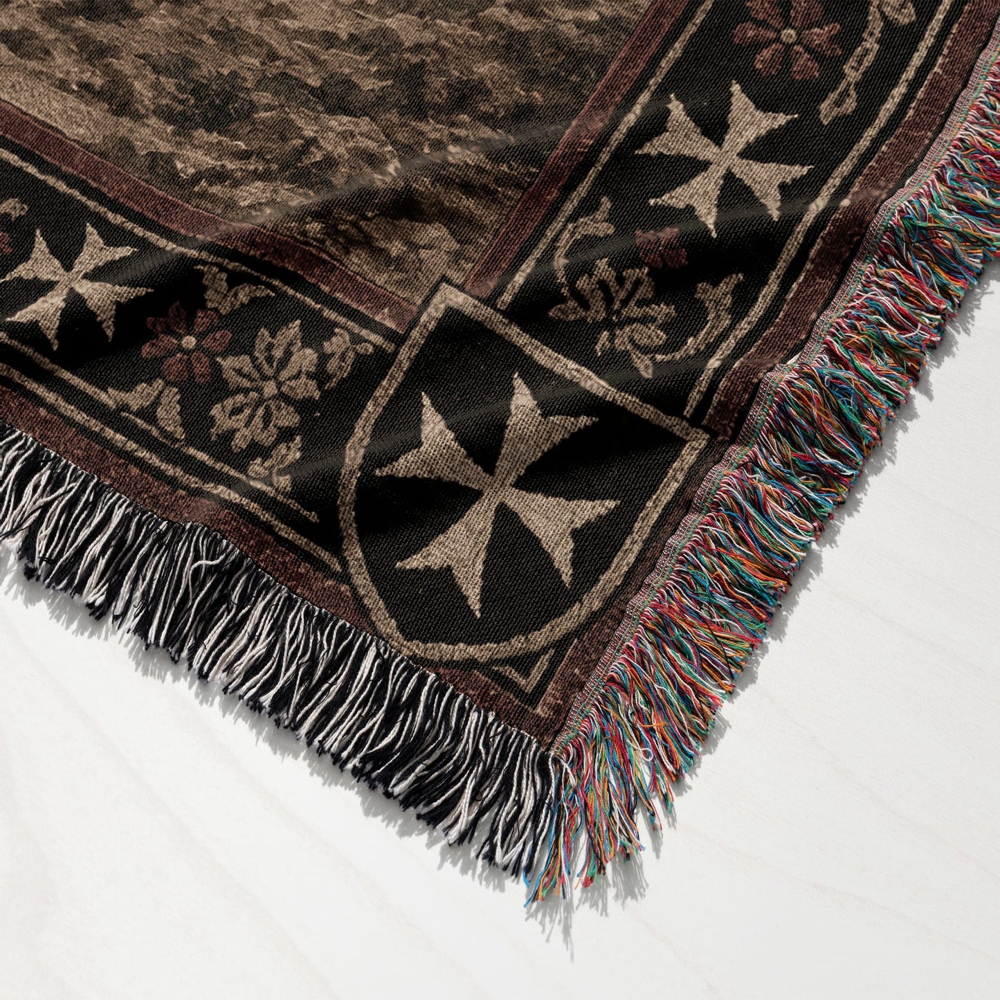 Brown woven blanket with Maltese crosses and fringed edges.