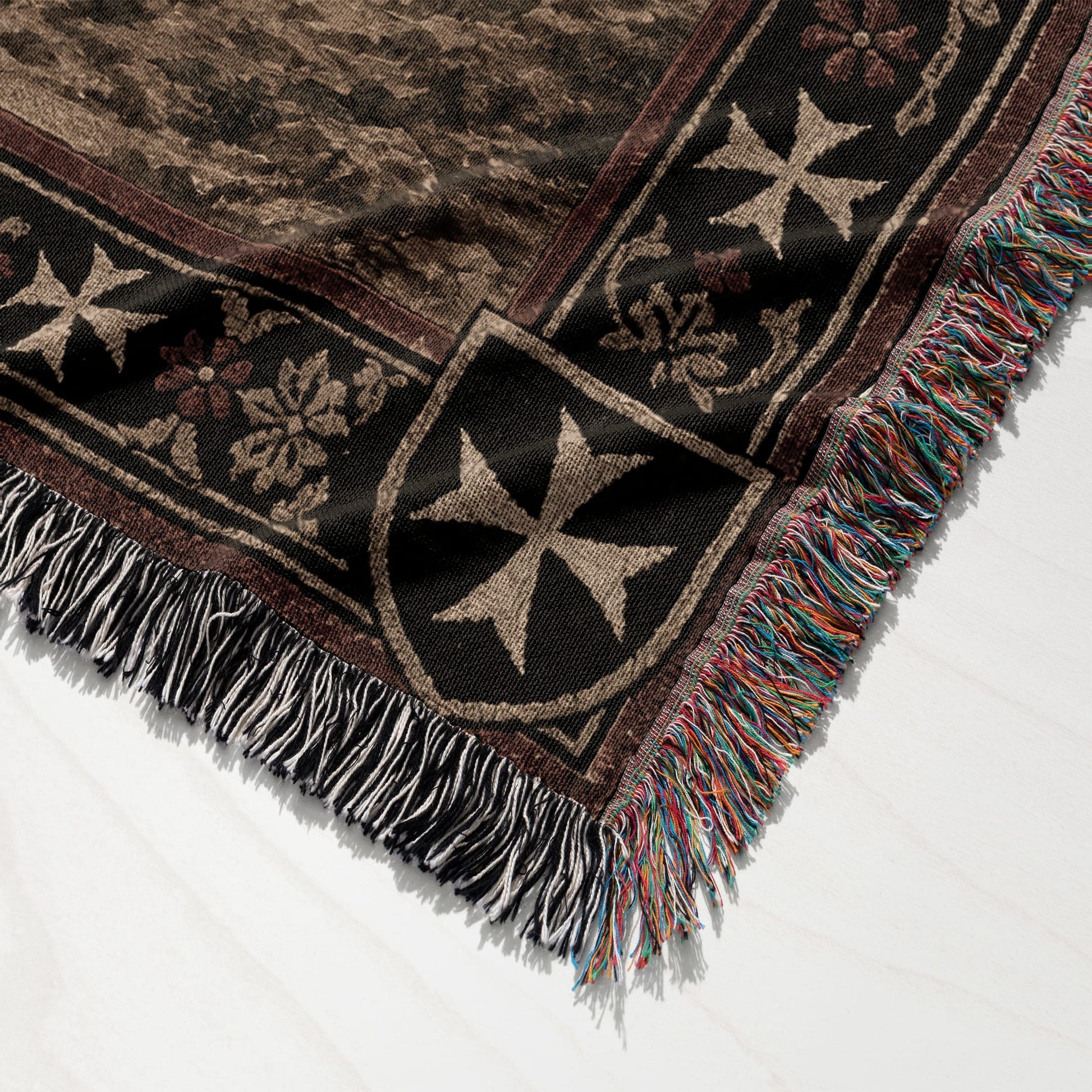 Brown woven blanket with Maltese crosses and fringed edges.