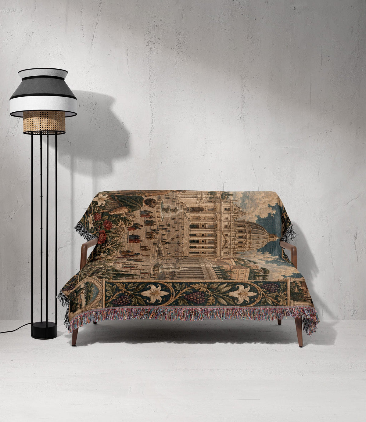 A woven tapestry blanket with a historic architectural scene draped over a modern wooden sofa.