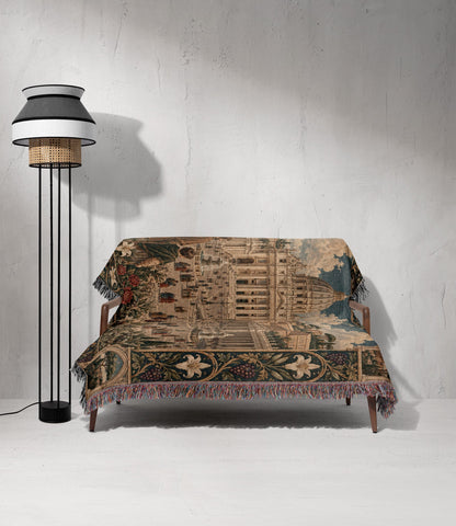 A woven tapestry blanket with a historic architectural scene draped over a modern wooden sofa.