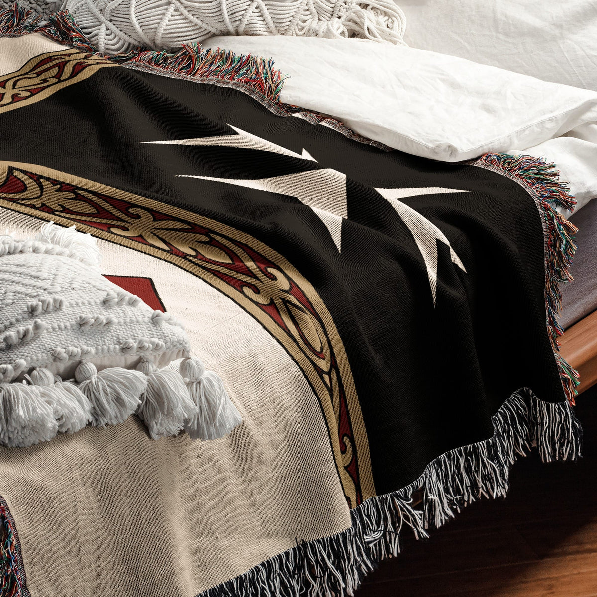 Black woven blanket with white lightning bolt pattern and colorful fringe.