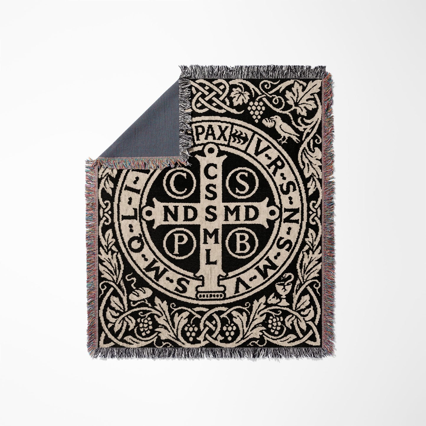 Black and tan woven blanket with Saint Benedict medal design and fringed edges.