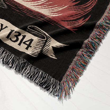 Woven throw blanket with fringe, featuring a banner with "Y 1314" and feathered wings.