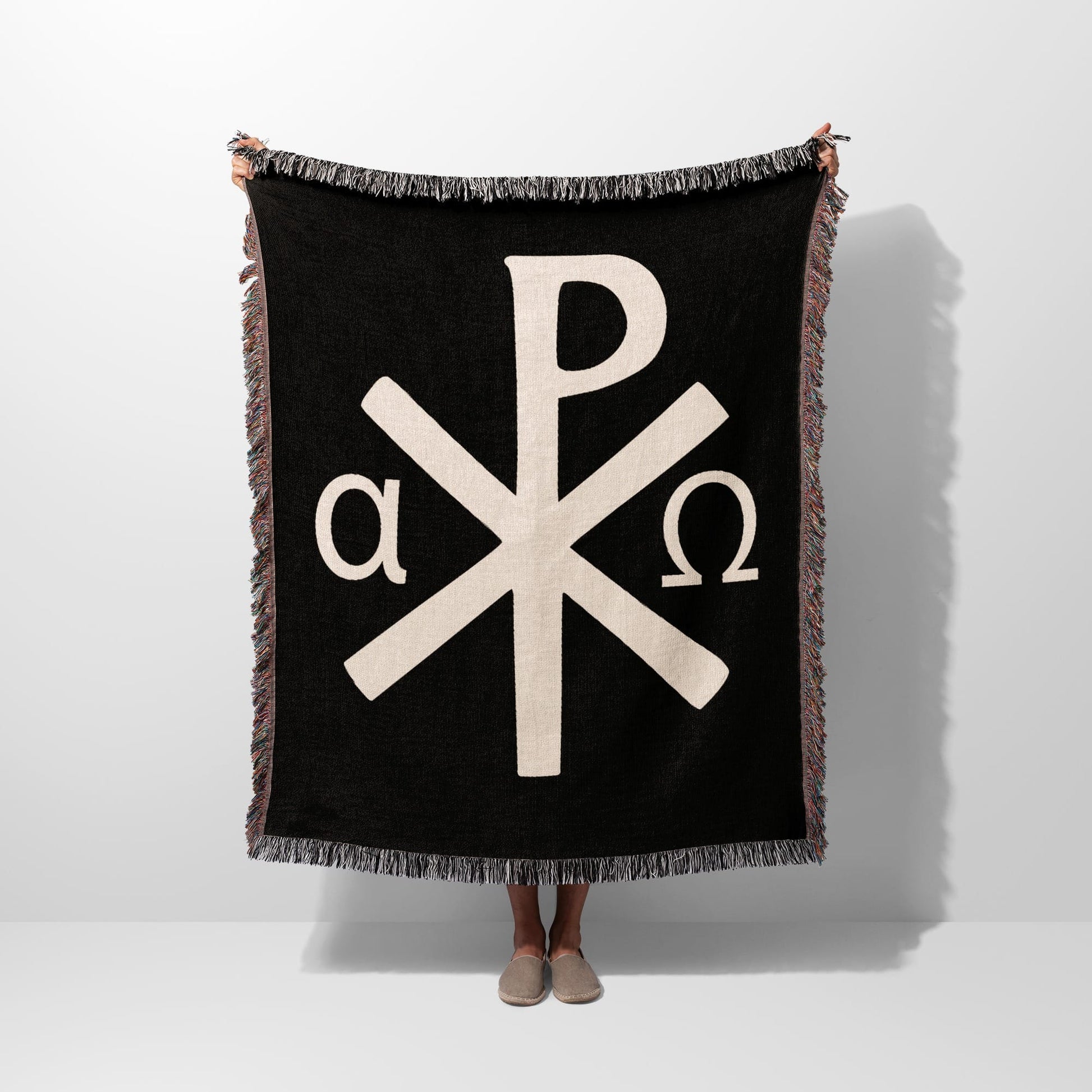 Black throw blanket with white Chi Rho and Alpha Omega symbols.