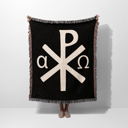 Black throw blanket with white Chi Rho and Alpha Omega symbols.