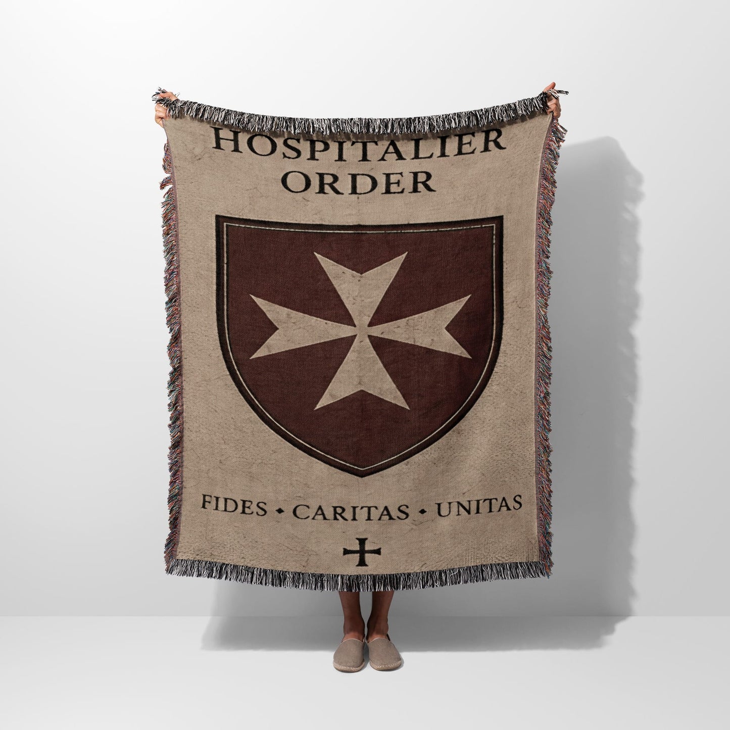 Hospitalier Order crest with Latin motto on a woven blanket.