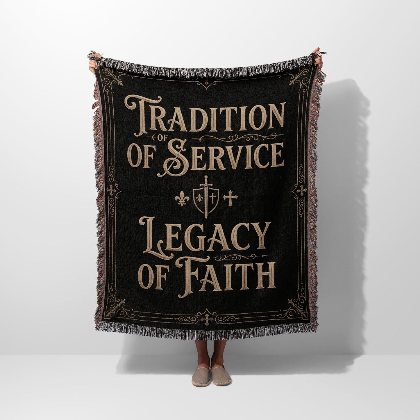 Black woven blanket with fringe, featuring text: Tradition of Service, Legacy of Faith.