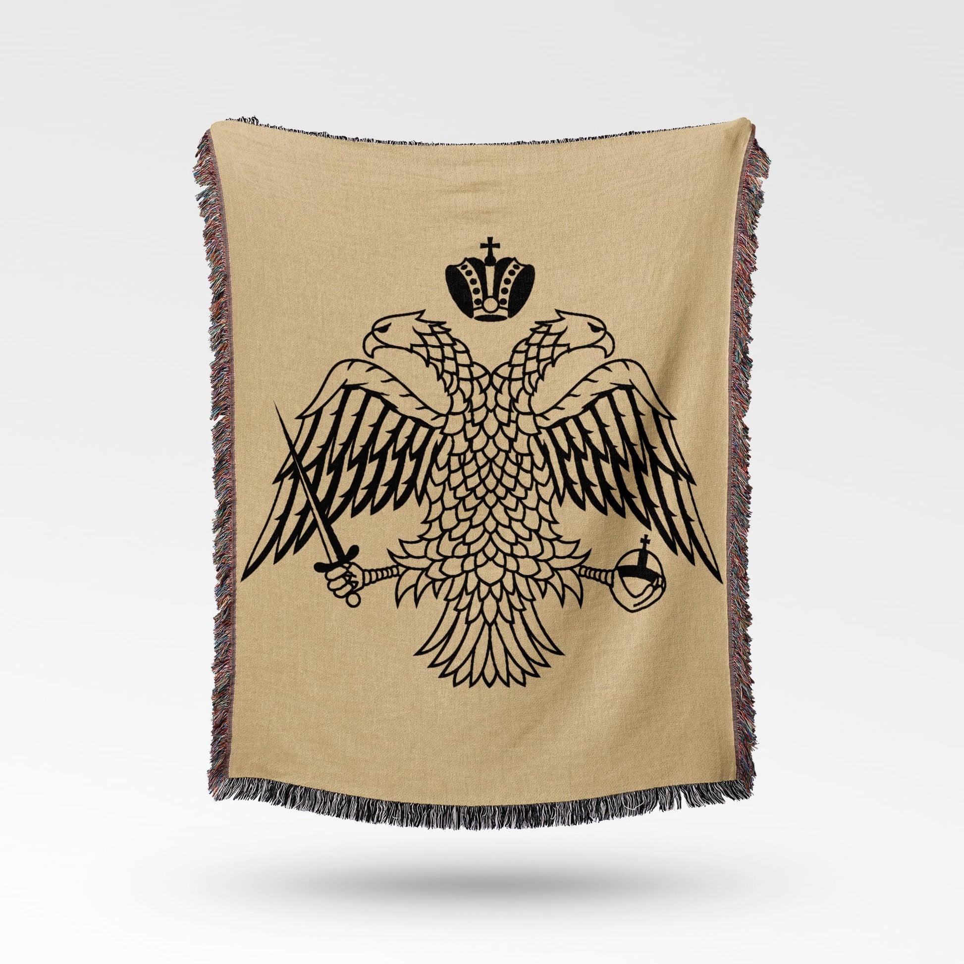 Black double-headed eagle crest on a tan woven blanket with fringed edges.