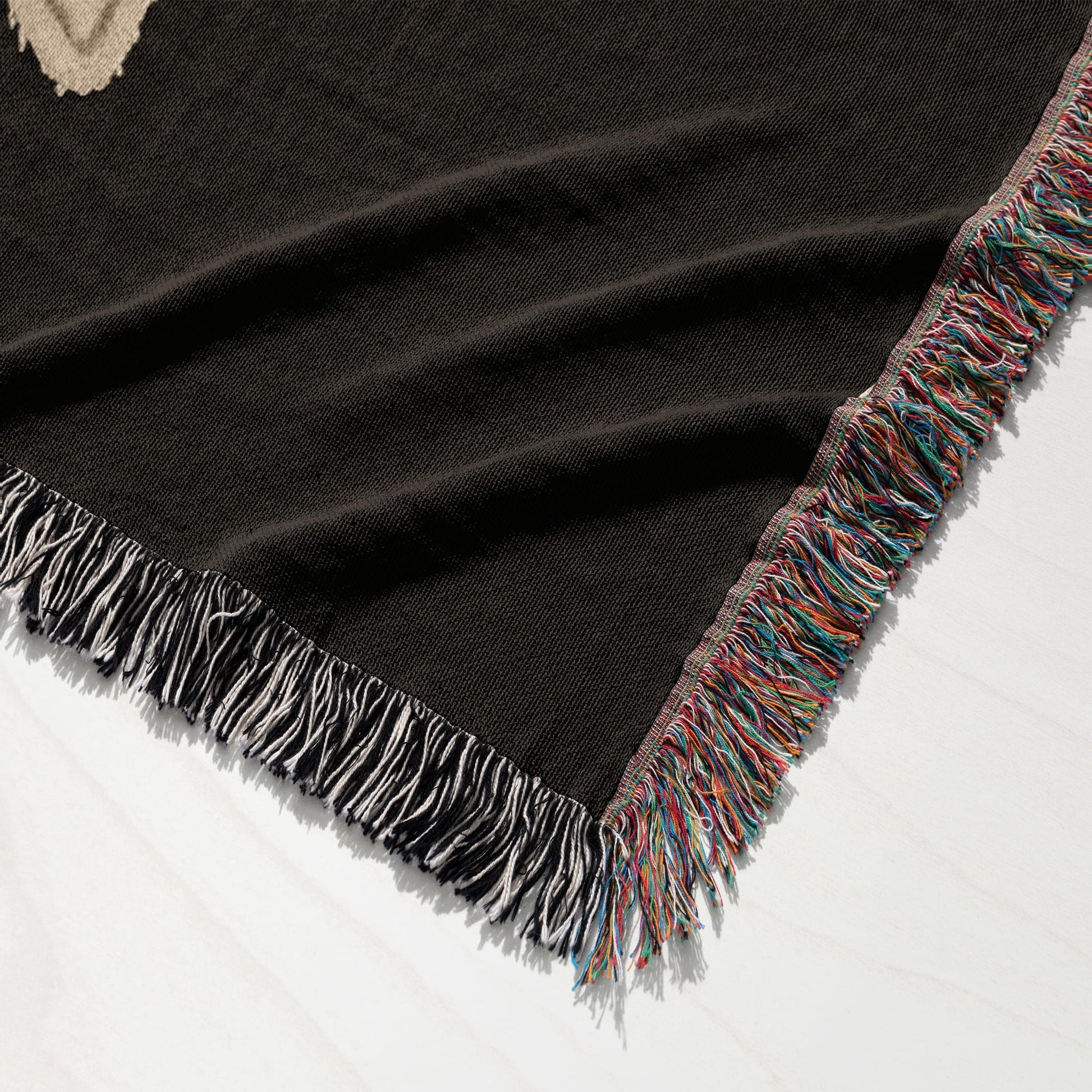Brown blanket with colorful fringe detail, showing woven texture.