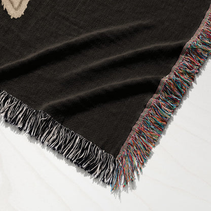 Brown blanket with colorful fringe detail, showing woven texture.