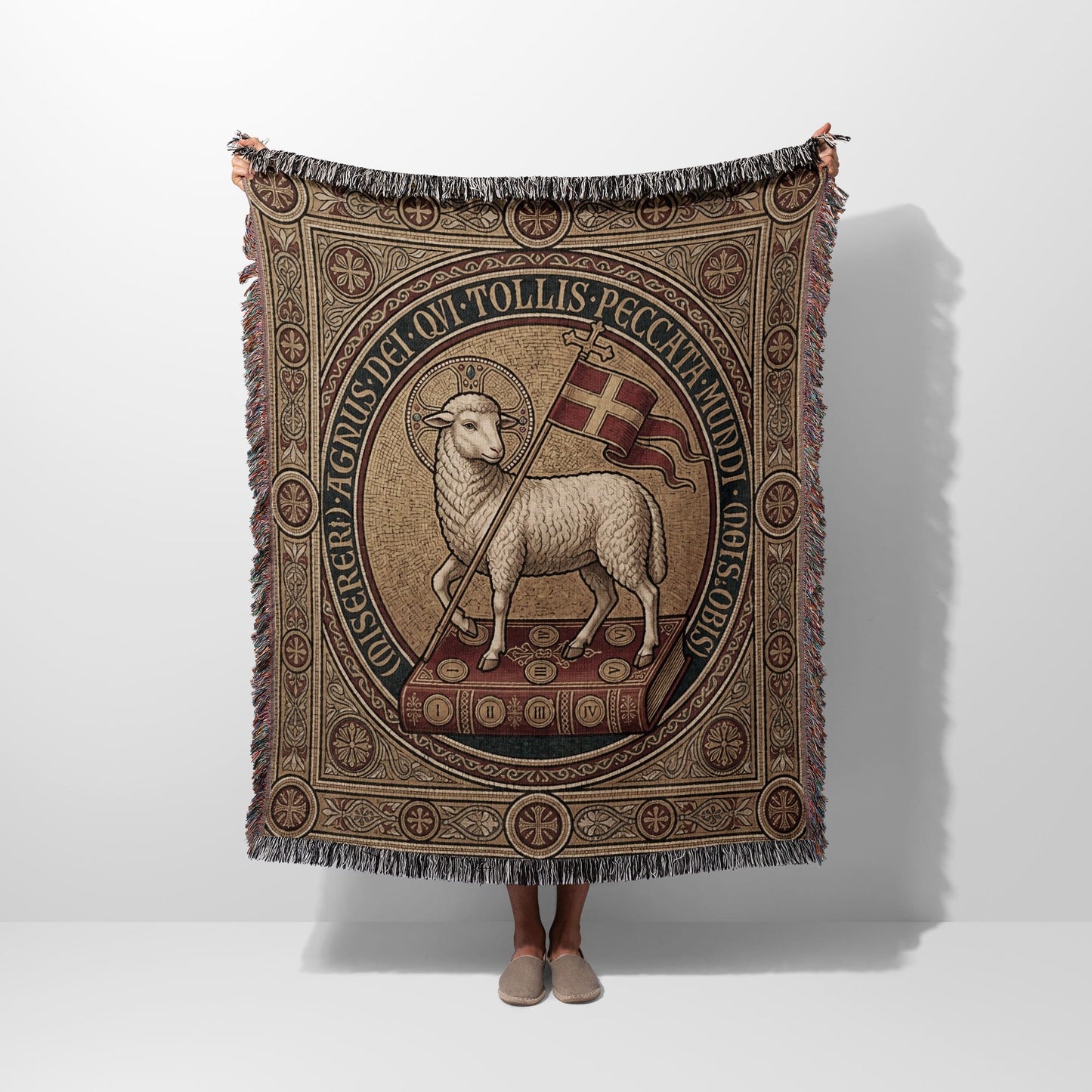 Woven tapestry blanket depicting a lamb holding a flag, surrounded by Latin text.
