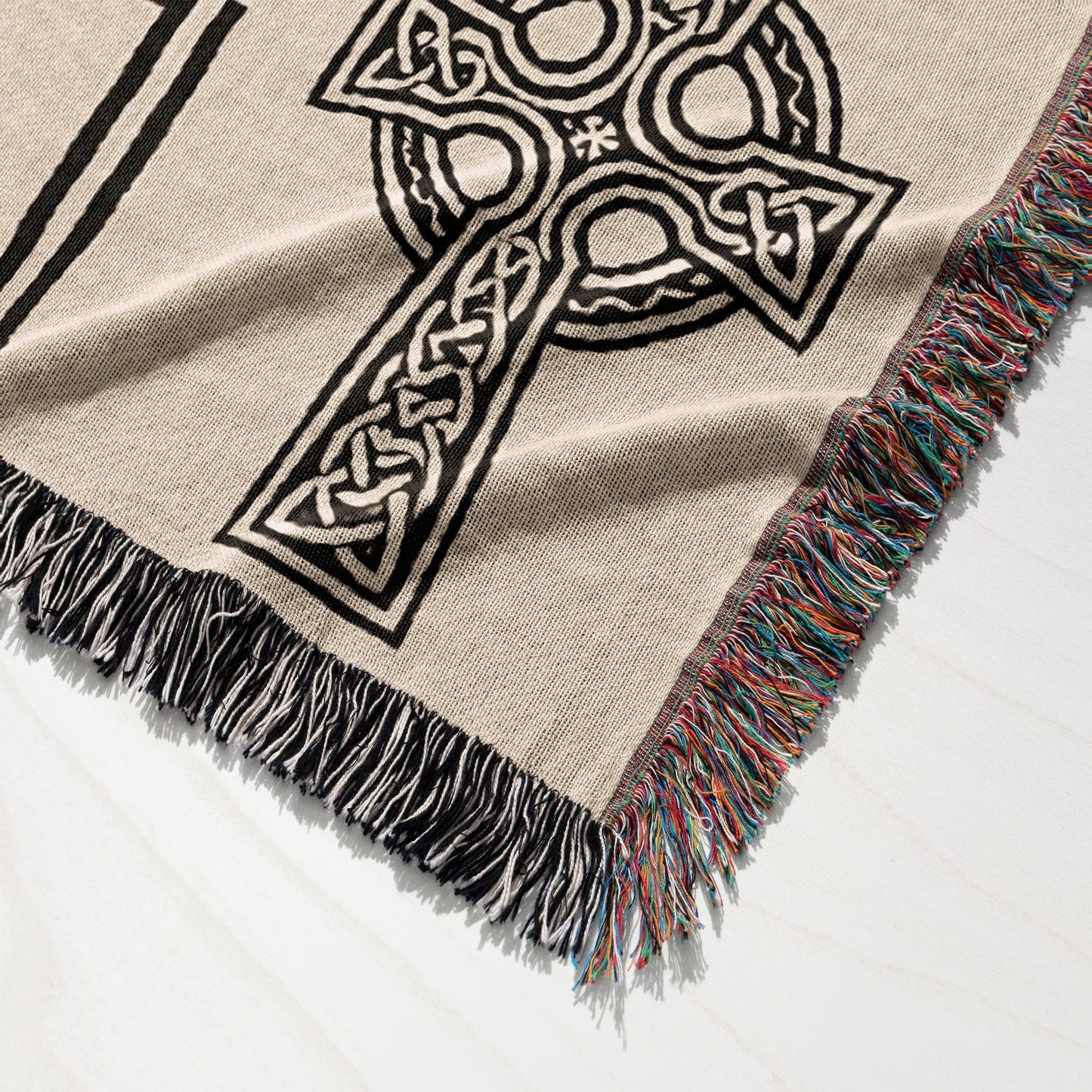 Woven throw blanket with Celtic knot cross design and fringed edges.