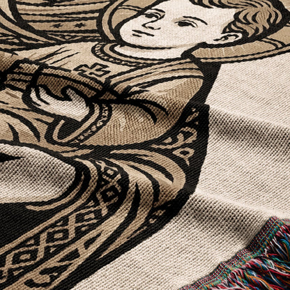 Tapestry blanket featuring an angelic child in a decorative border with fringed edge.