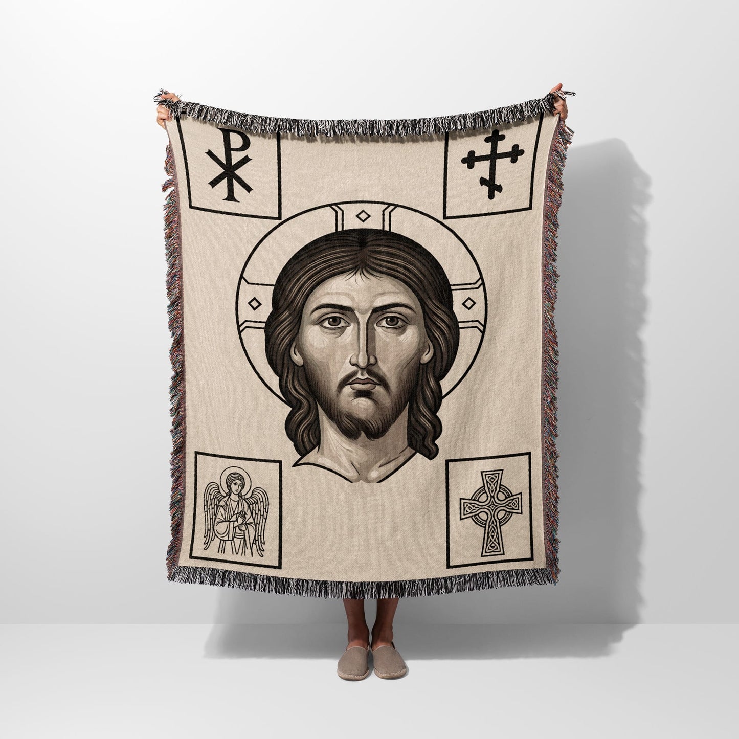 Tapestry blanket featuring Christ's face surrounded by religious symbols.