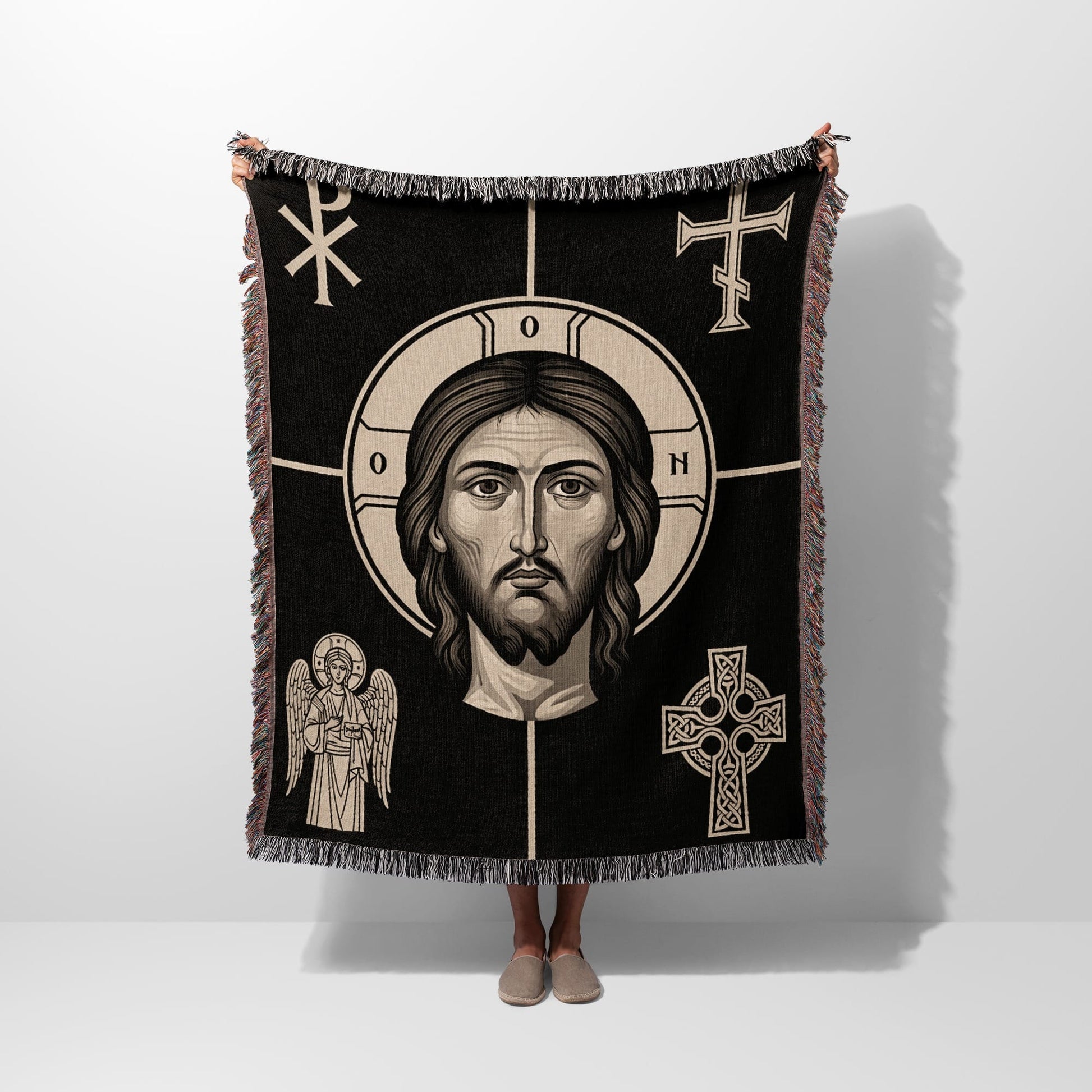 Black throw blanket with Jesus Christ's face and religious symbols.