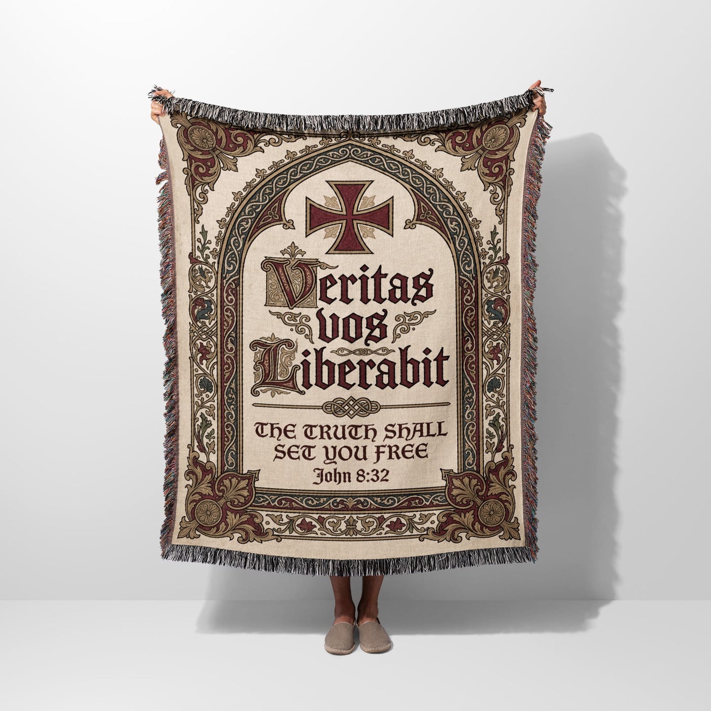Tapestry blanket with ornate cross, Latin text "Veritas vos liberabit," and Bible verse John 8:32.