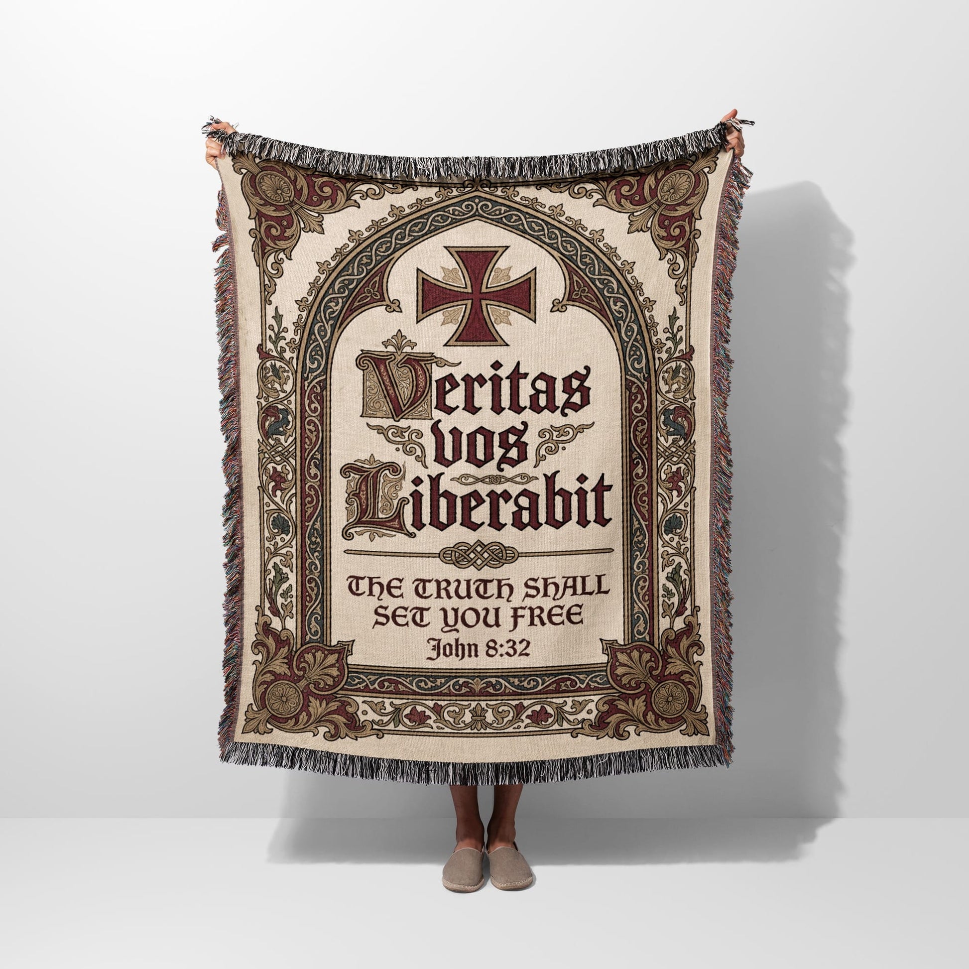 Tapestry blanket with ornate cross, Latin text "Veritas vos liberabit," and Bible verse John 8:32.
