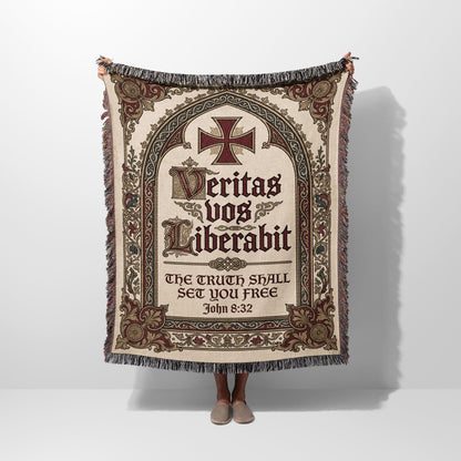 Tapestry blanket with ornate cross, Latin text "Veritas vos liberabit," and Bible verse John 8:32.
