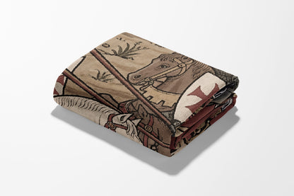 Folded tapestry with medieval knight on horseback and red cross emblem.