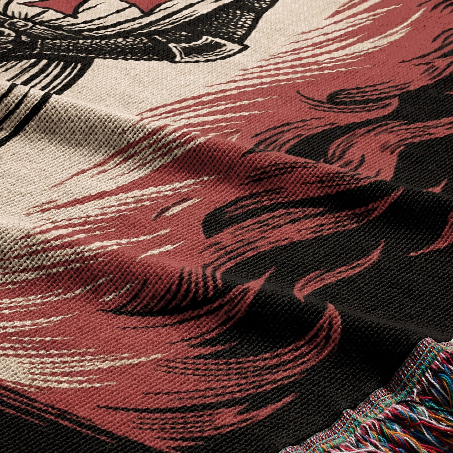 Woven blanket with tribal fire pattern and fringed edge.
