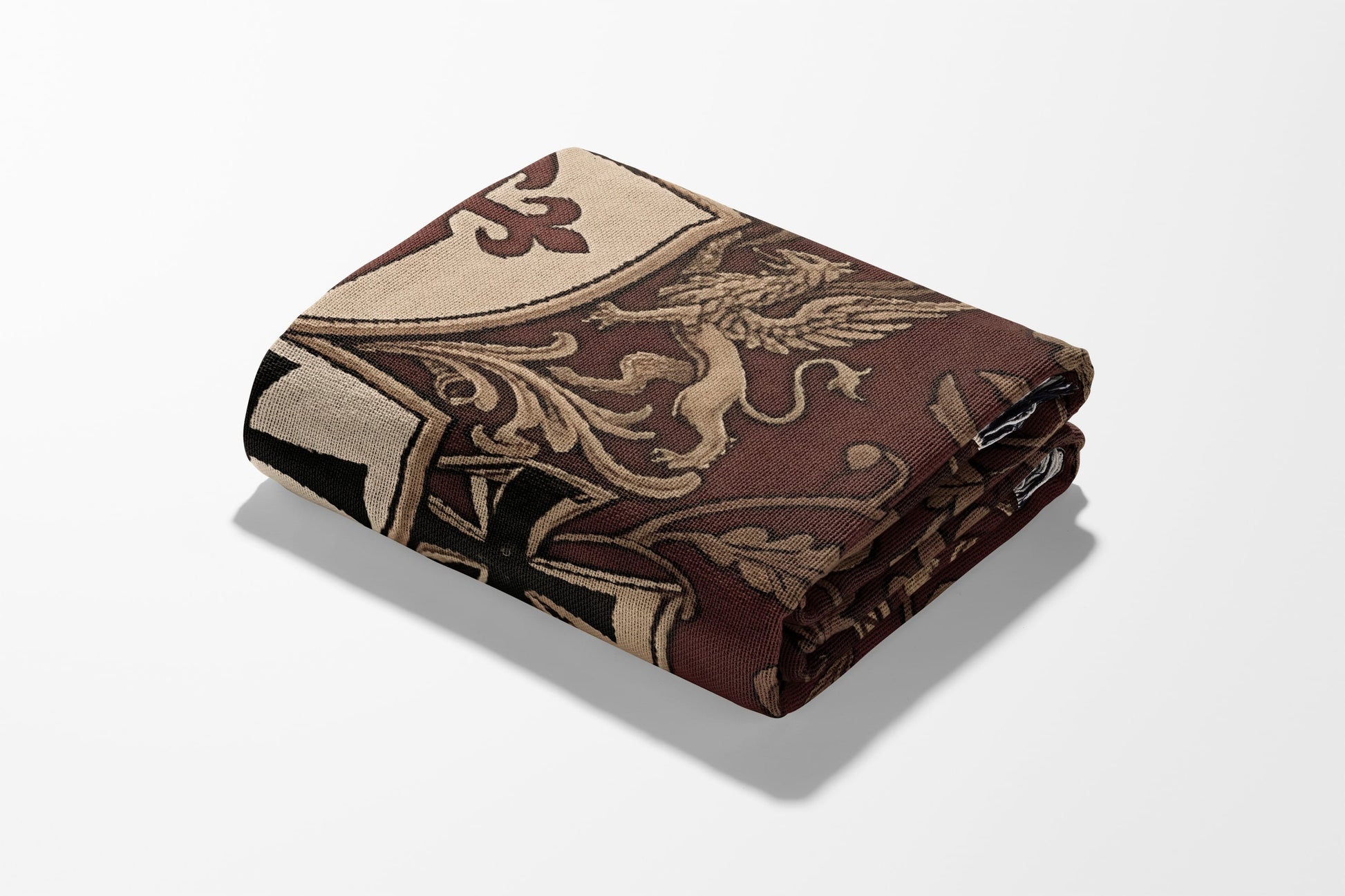 Folded throw blanket with a brown, beige, and black heraldic design.