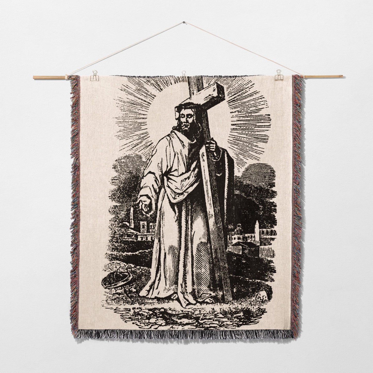 Black and white tapestry depicting Jesus Christ carrying a cross, with sunburst rays.