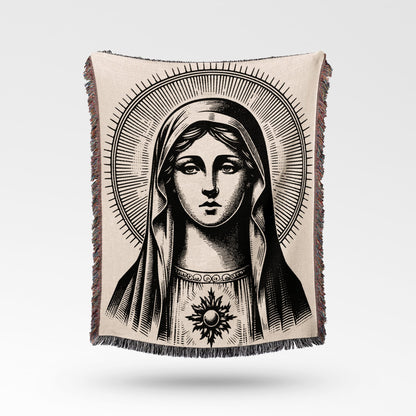 Black and white tapestry depicting the Virgin Mary with a halo and radiant sun emblem.