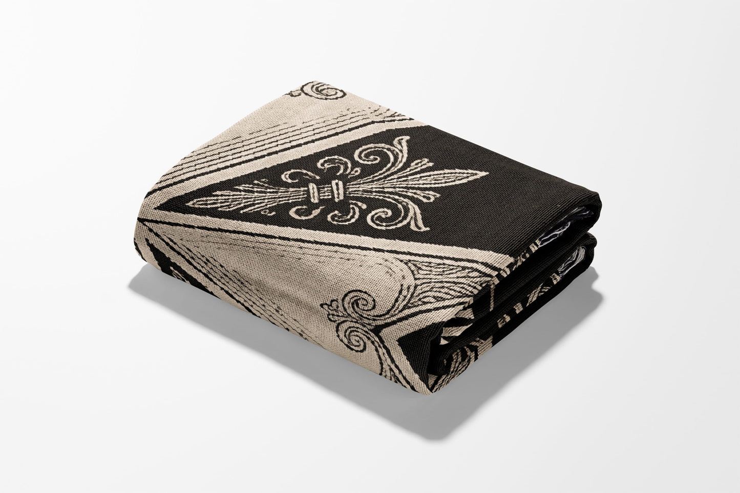 Folded blanket with black and cream fleur-de-lis and geometric pattern.