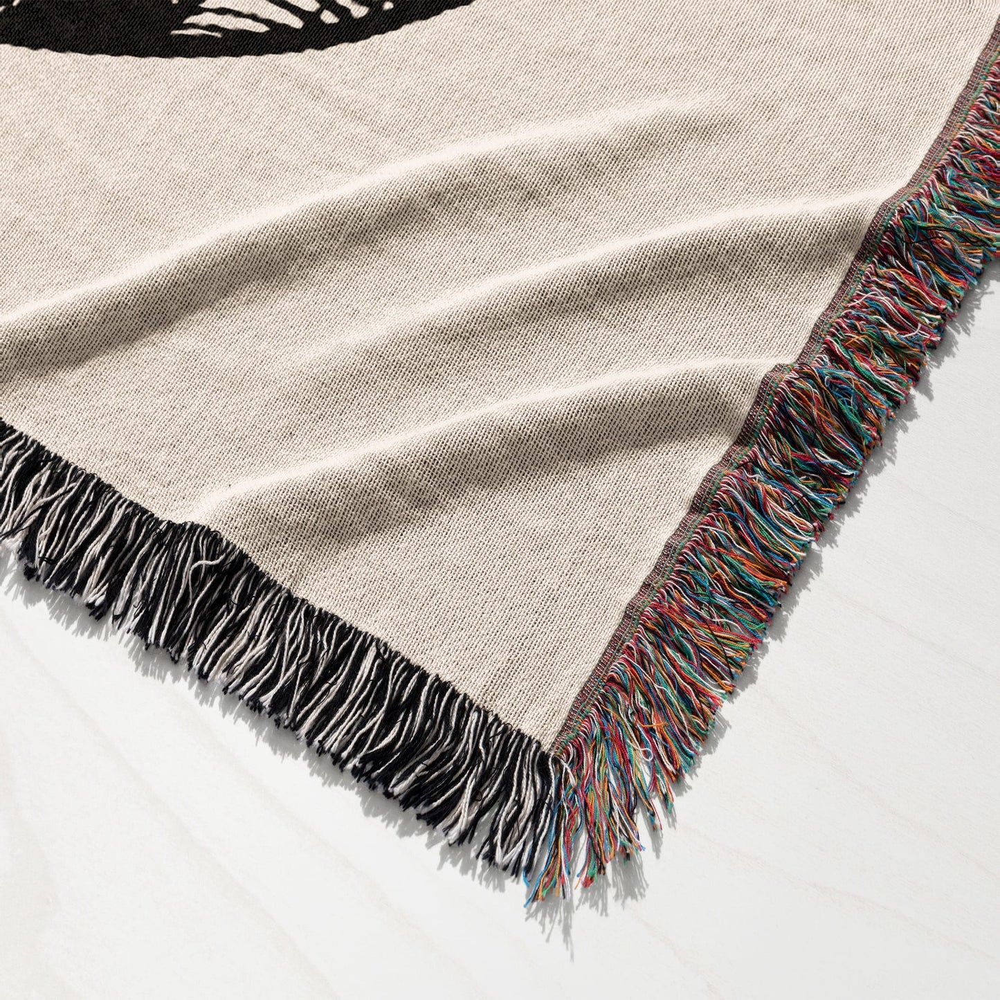 Woven tapestry throw blanket with a cream background and a black graphic.