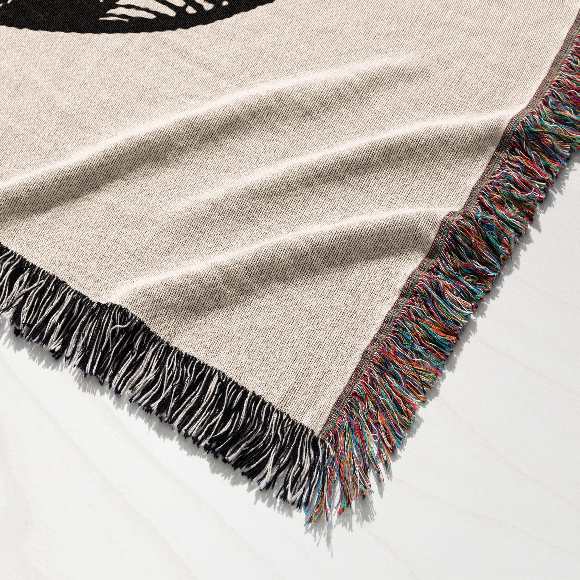 Woven tapestry throw blanket with a cream background and a black graphic.