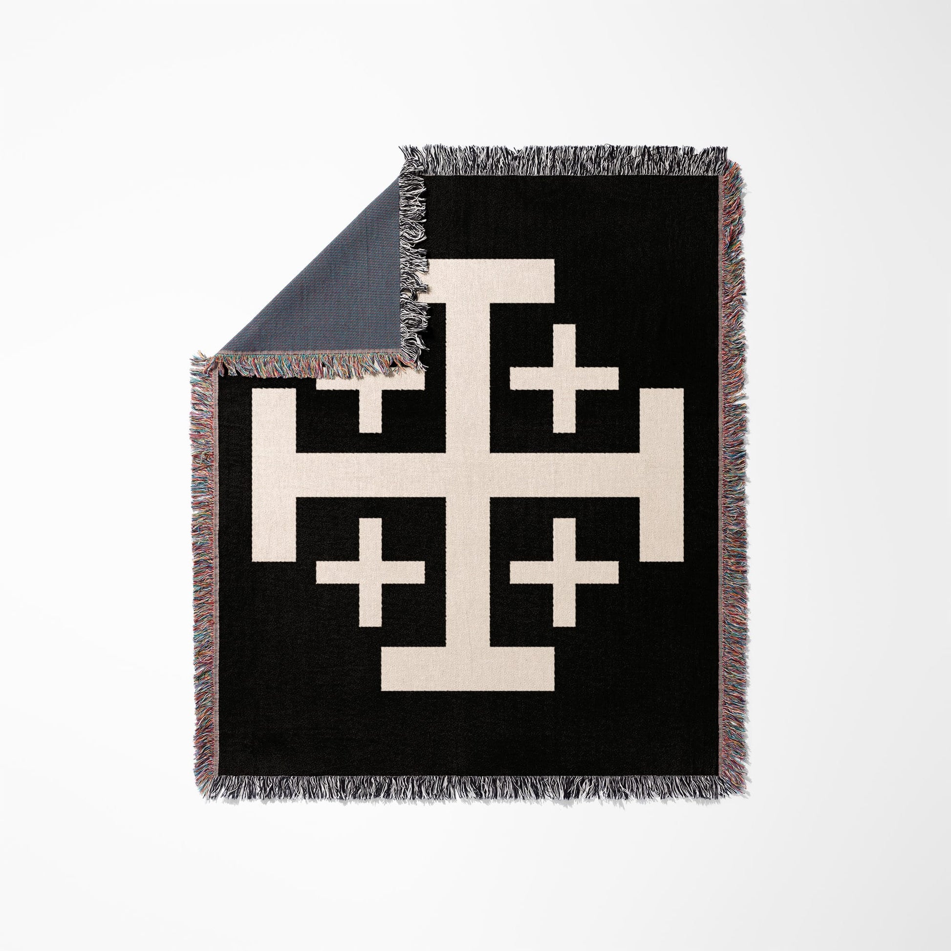 Black woven blanket with a cream Jerusalem cross design and frayed edges.
