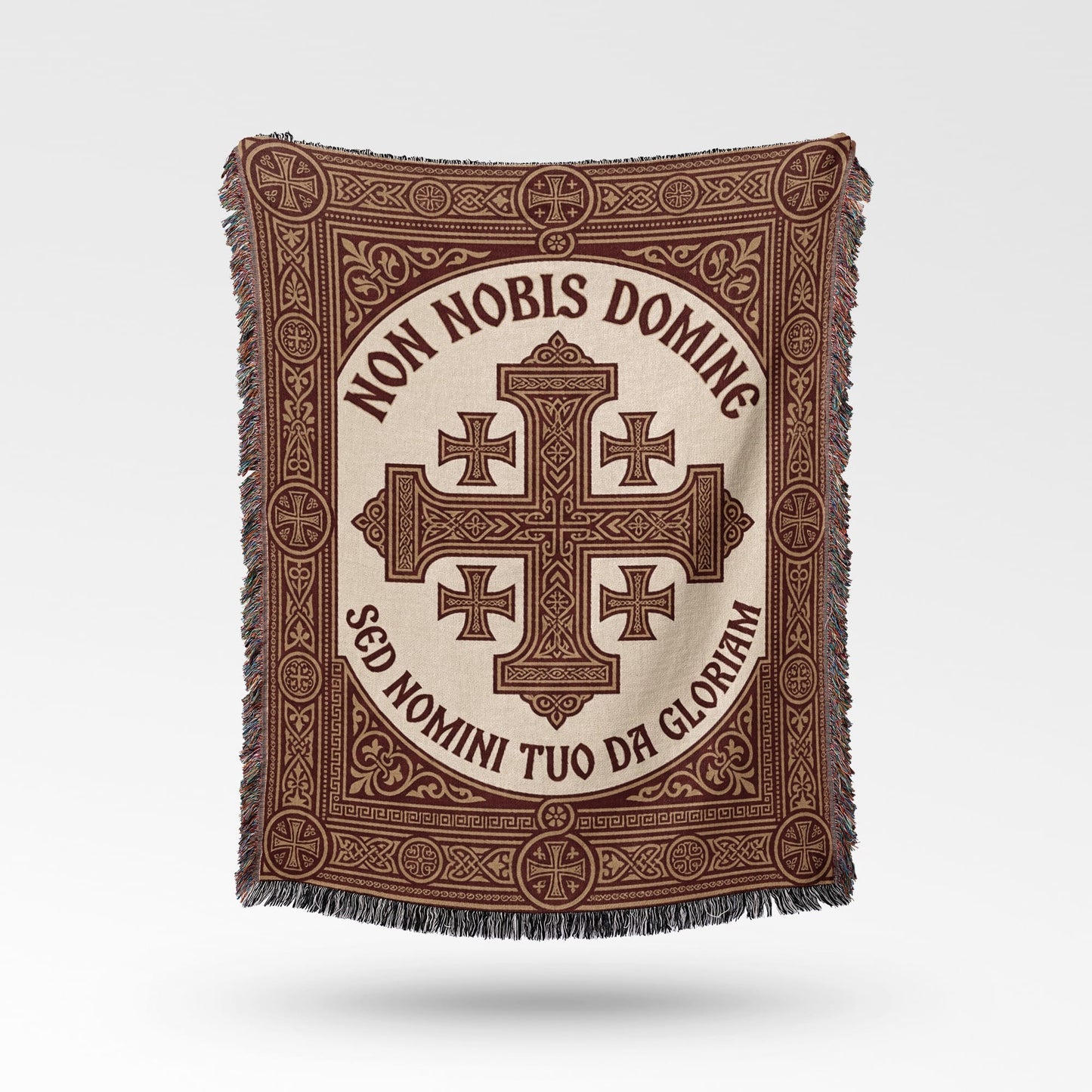 Text "Non Nobis Domine Sed Nomini Tuo Da Gloriam" on a woven throw with cross design.