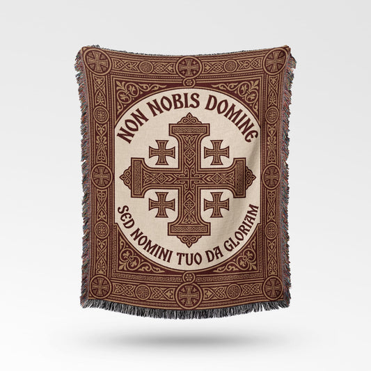 Text "Non Nobis Domine Sed Nomini Tuo Da Gloriam" on a woven throw with cross design.